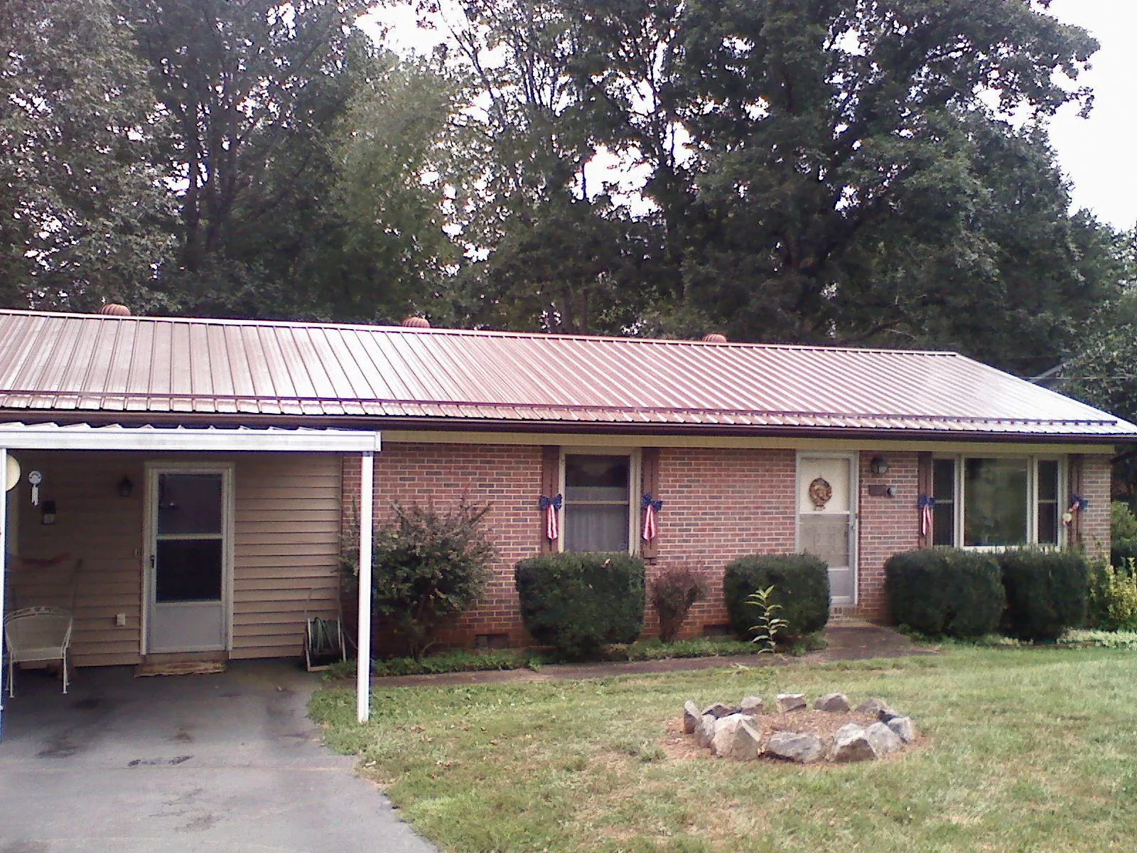 Bronze metal roof and carport on a brick ranch home — Roof Repair work by our crew in Constable